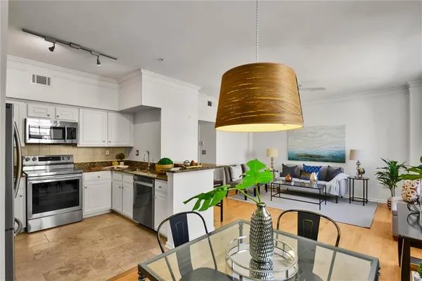 a kitchen with stainless steel appliances granite countertop a stove and white cabinets
