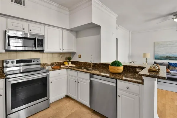 a kitchen with stainless steel appliances granite countertop a sink and stove top oven