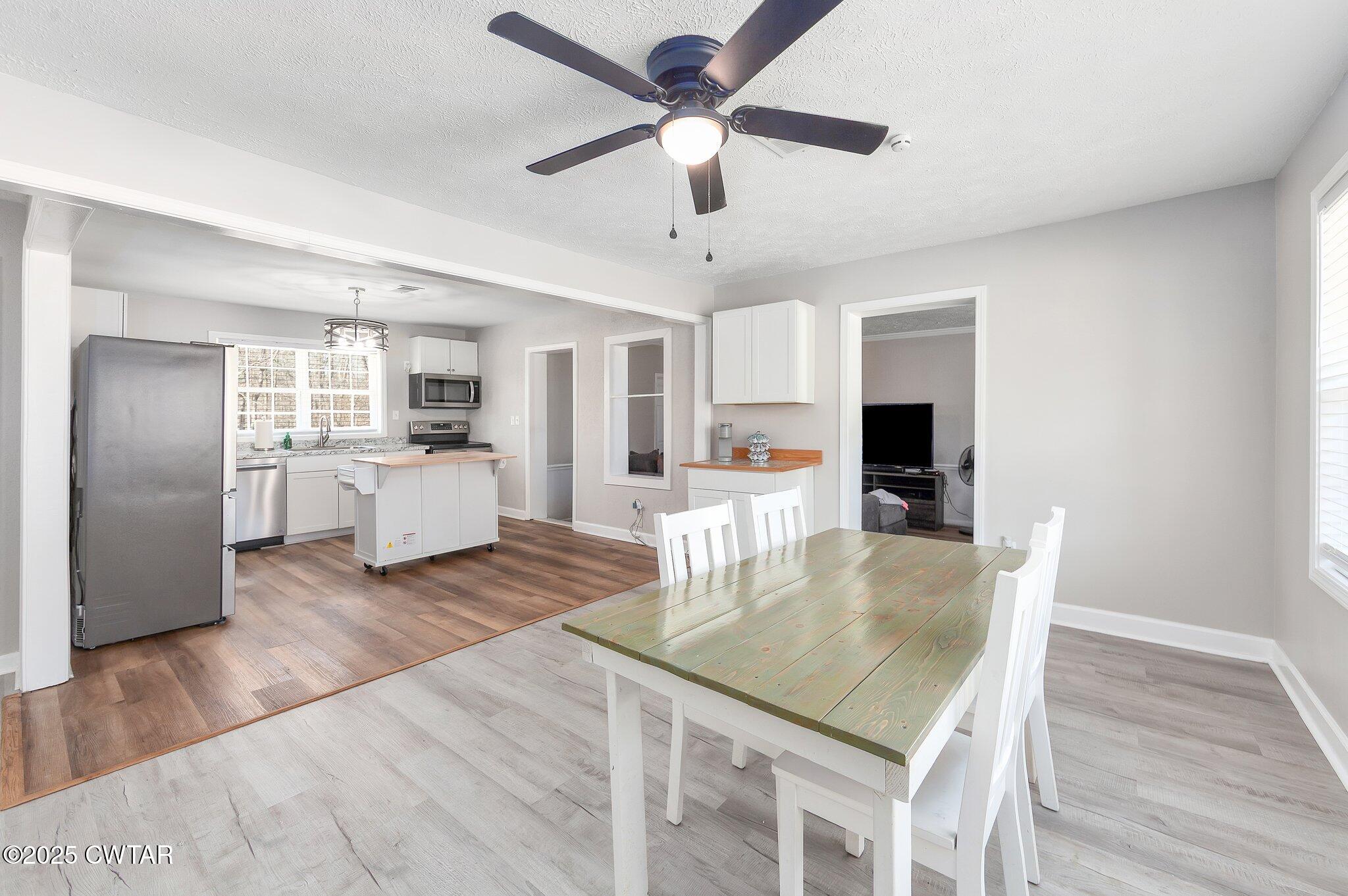 4260 Old Friendship Road Finger, TN 38334 - Photo 6 of 26 a kitchen with stainless steel appliances granite countertop a refrigerator a stove a microwave oven a sink with island and chairs