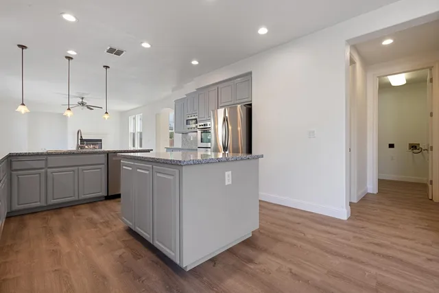 a kitchen with stainless steel appliances granite countertop a refrigerator stove and microwave