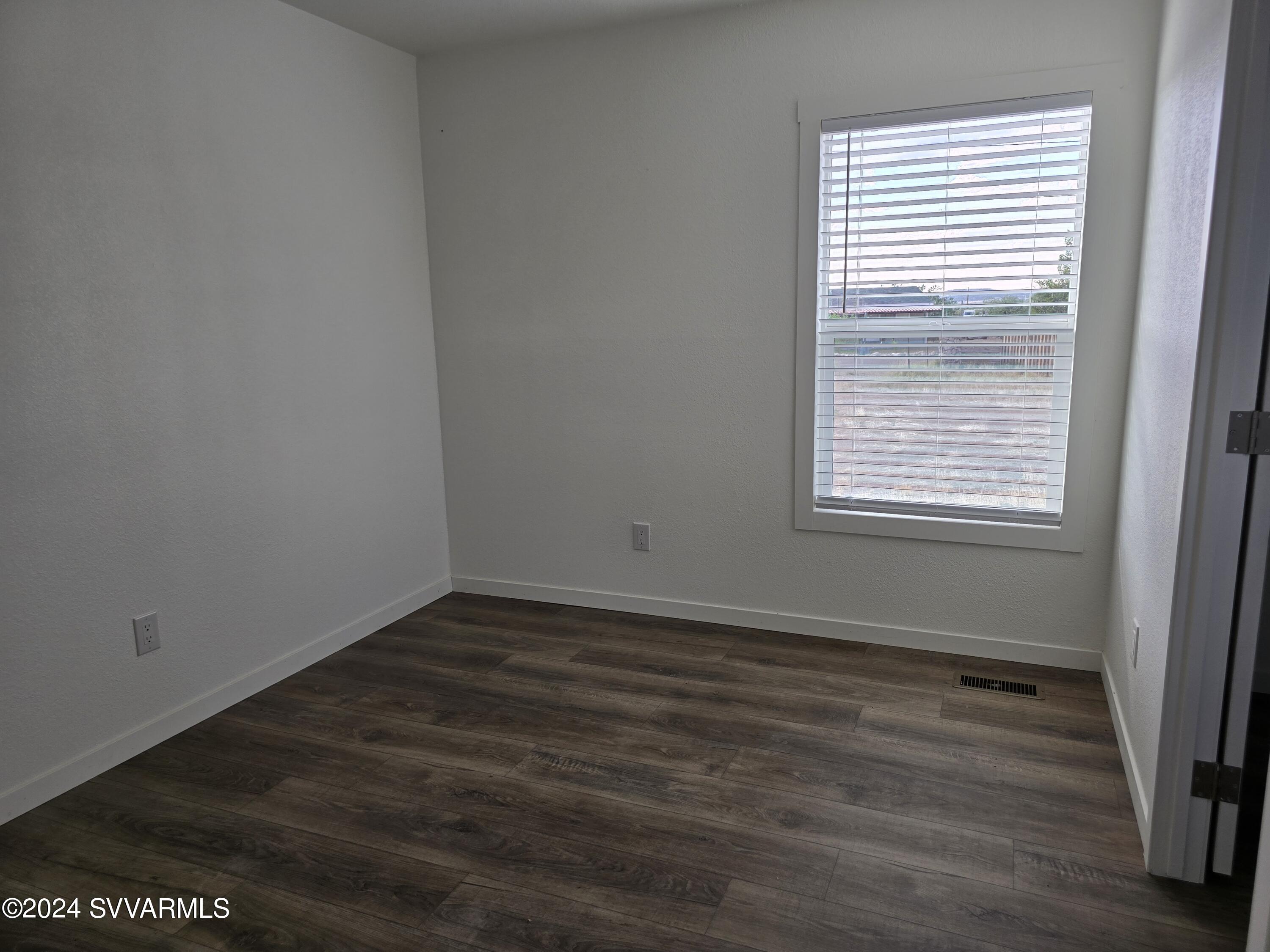 5205 Albatross Road Rimrock, AZ 86335 - Photo 17 of 23 a view of an empty room with wooden floor and a window