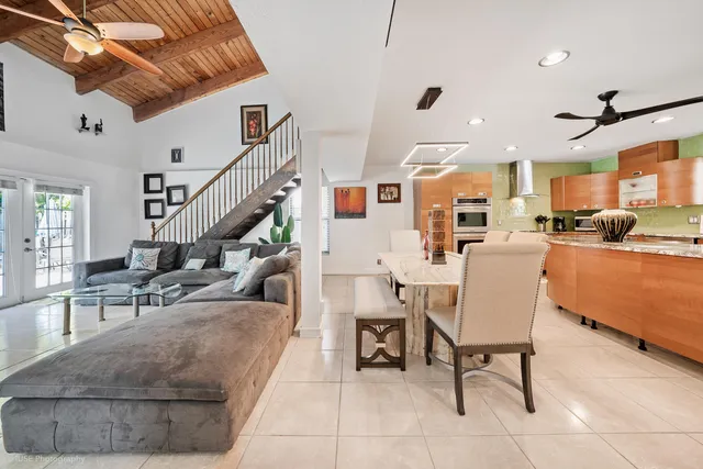 a living room with furniture and a dining table with projector the view