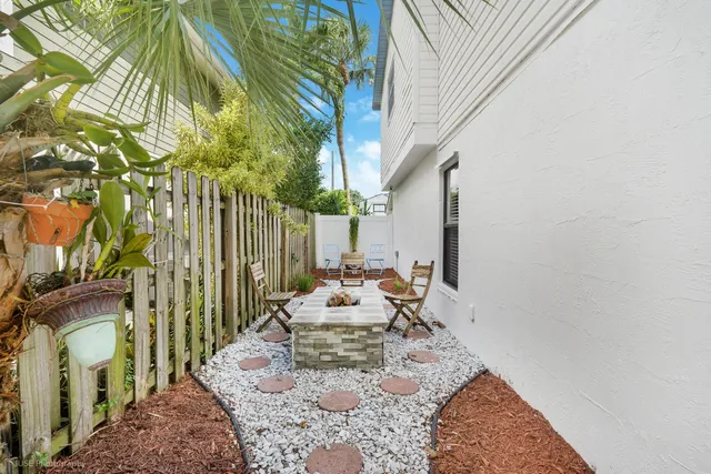 a view of a patio with a table chairs and a potted plant