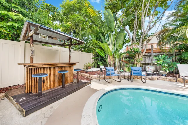 a view of backyard with swimming pool and furniture