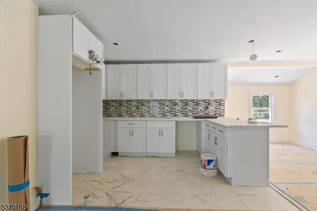 a kitchen with granite countertop white cabinets and white appliances