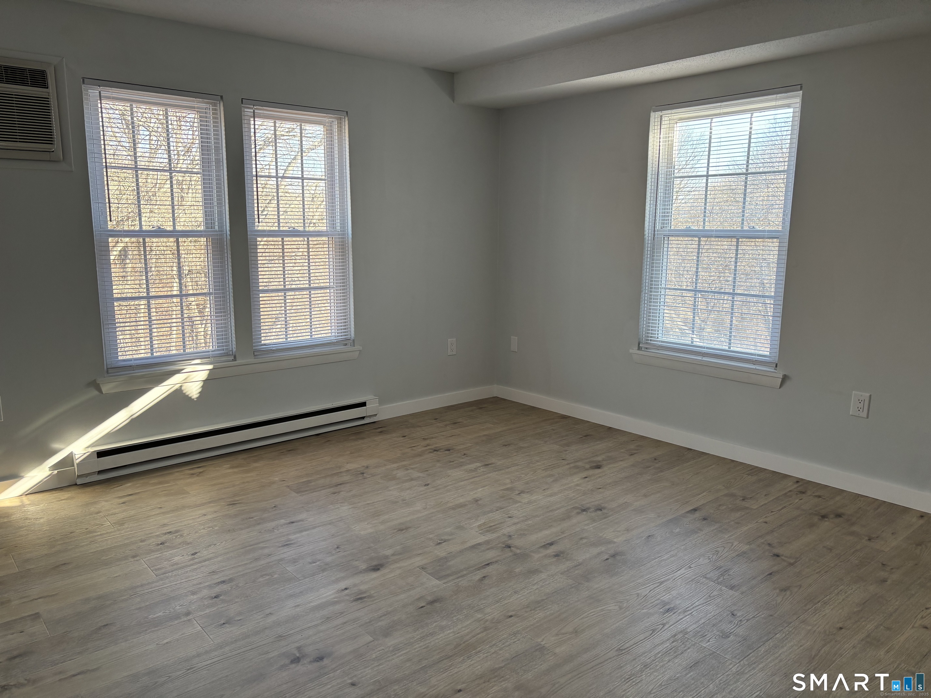 82 Longview Street, Unit 36 Waterford, CT 06385 - Photo 12 of 14 an empty room with wooden floor and windows