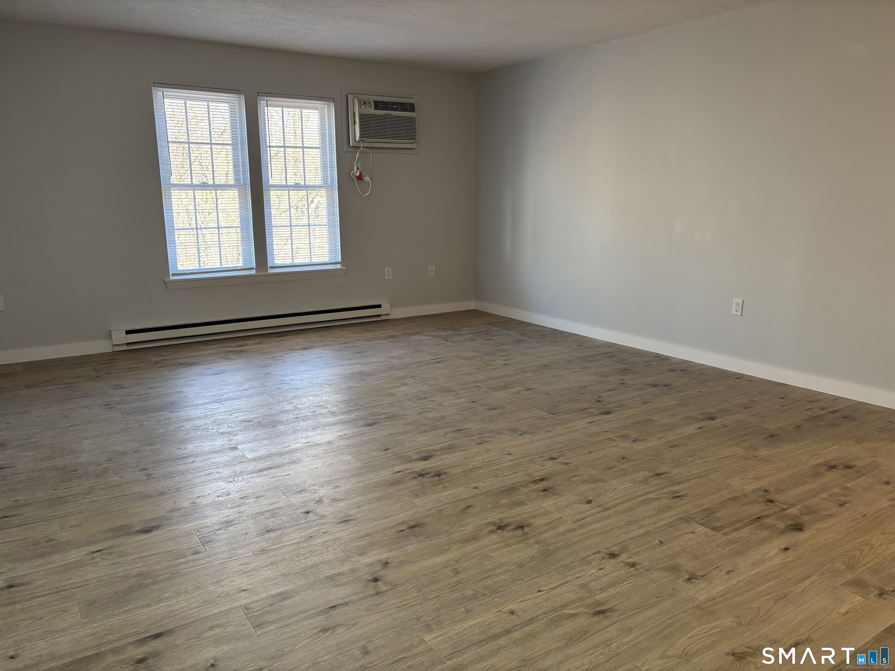 82 Longview Street, Unit 36 Waterford, CT 06385 - Photo 9 of 14 an empty room with wooden floor and windows
