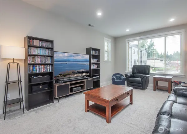 a living room with furniture a flat screen tv and a large window