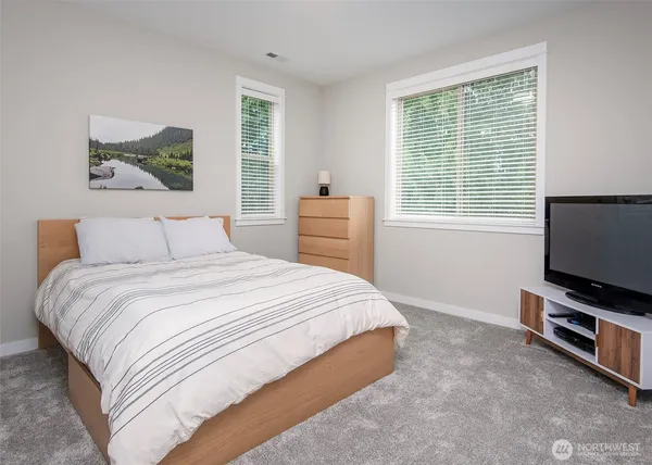 a bedroom with a bed and a flat screen tv