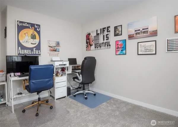 a view of a workspace with furniture and a window