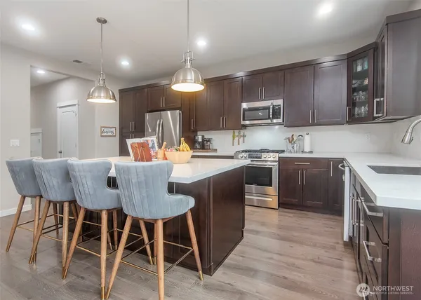 a kitchen with a table chairs sink and cabinets