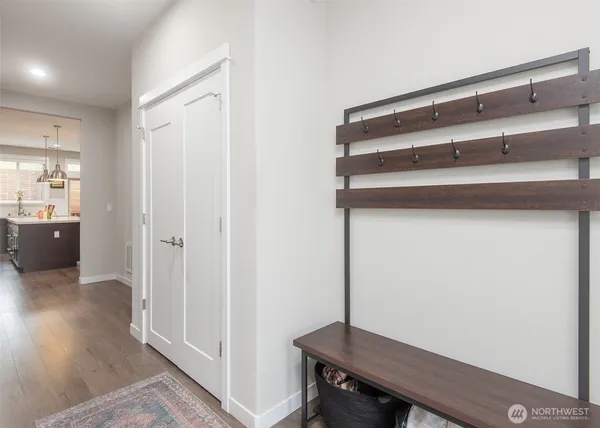 a view of a hallway with wooden floor and closet