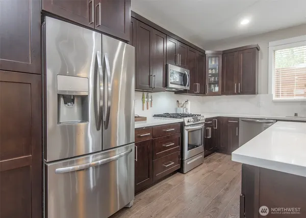 a kitchen with stainless steel appliances a refrigerator sink and cabinets