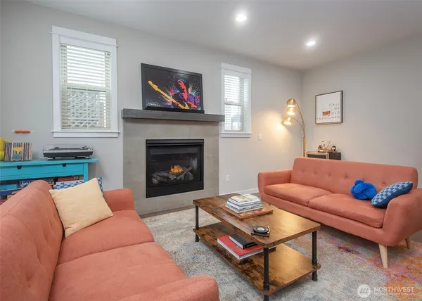 a living room with furniture a flat screen tv and a fireplace