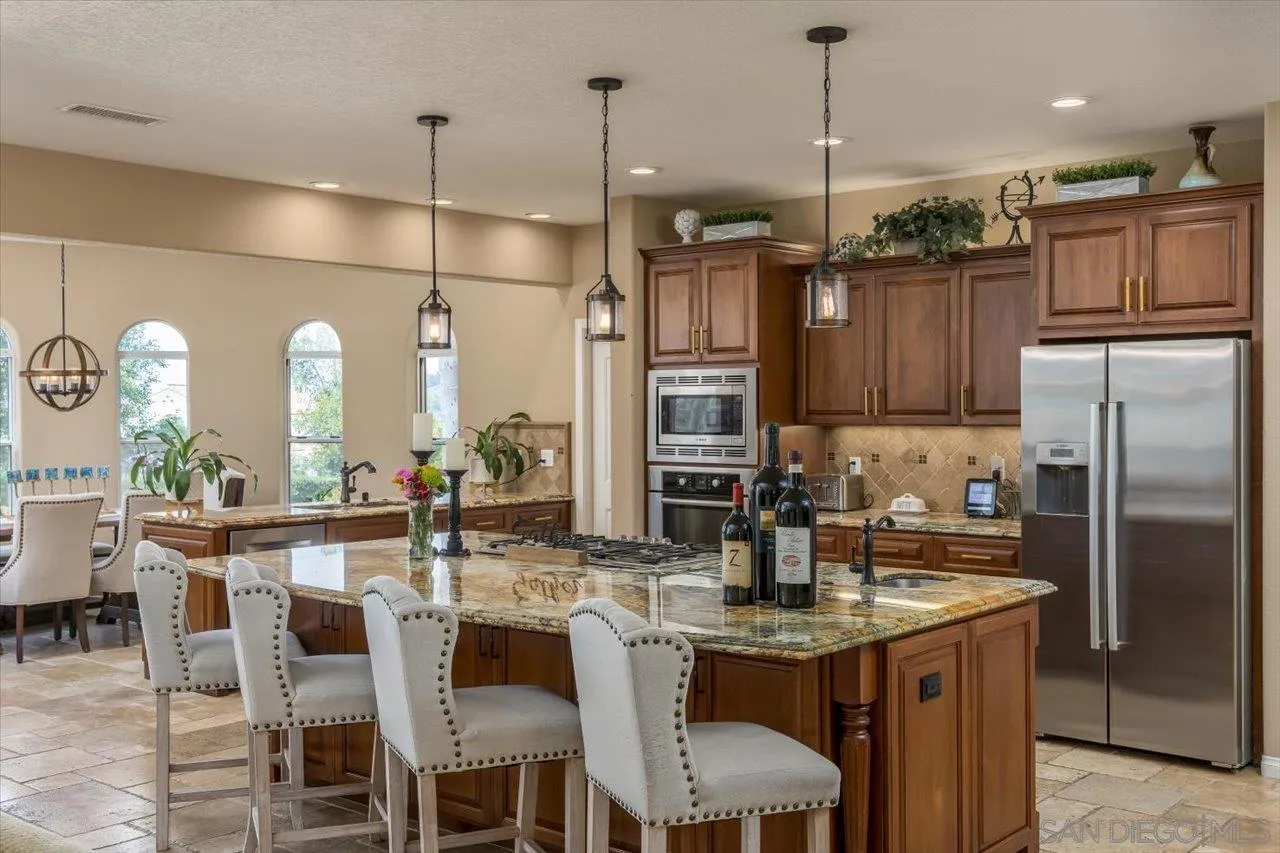 16348 Country Day Road Poway, CA 92064 - Photo 8 of 38 a kitchen with stainless steel appliances granite countertop a kitchen island a stove and a refrigerator