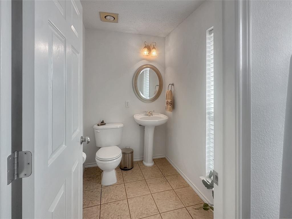 10717 Greenview Court Benbrook, TX 76126 - Photo 21 of 36 a bathroom with a toilet a sink and a mirror