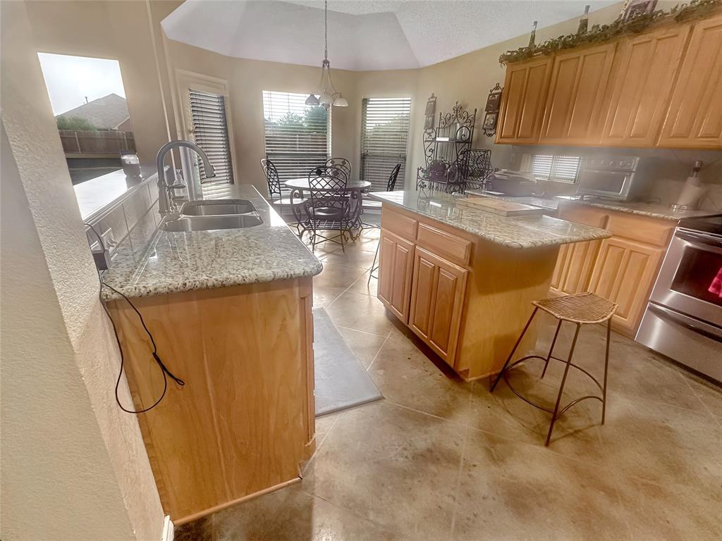 10717 Greenview Court Benbrook, TX 76126 - Photo 5 of 36 a kitchen with kitchen island a counter top space a sink and appliances
