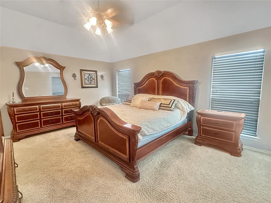 10717 Greenview Court Benbrook, TX 76126 - Photo 6 of 36 a bedroom with a bed lamp and a chandelier