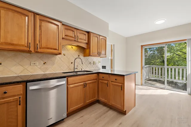a kitchen with granite countertop stainless steel appliances a sink and cabinets