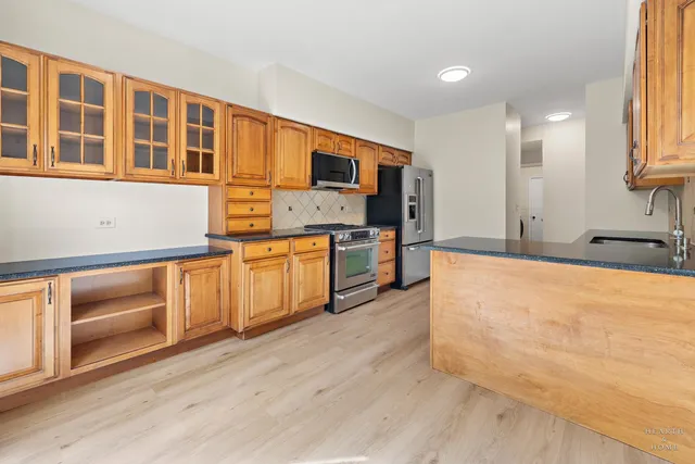 a large kitchen with stainless steel appliances granite countertop a stove and a sink