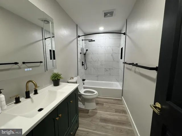 a bathroom with a double vanity sink toilet tub and shower