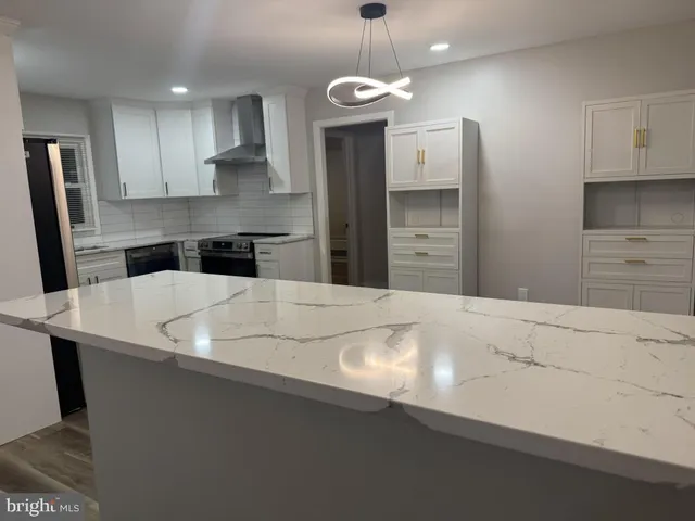 a kitchen with kitchen island a sink stainless steel appliances and cabinets