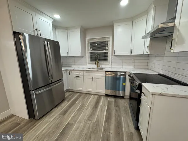 a kitchen with a sink a refrigerator a microwave and cabinets