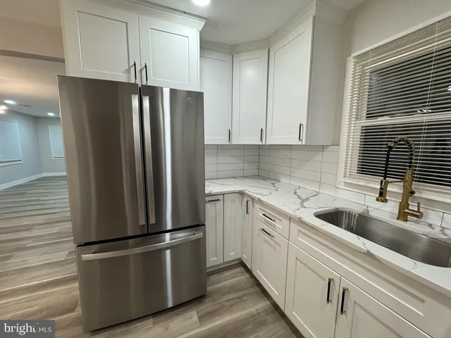 a kitchen with a refrigerator sink and cabinets