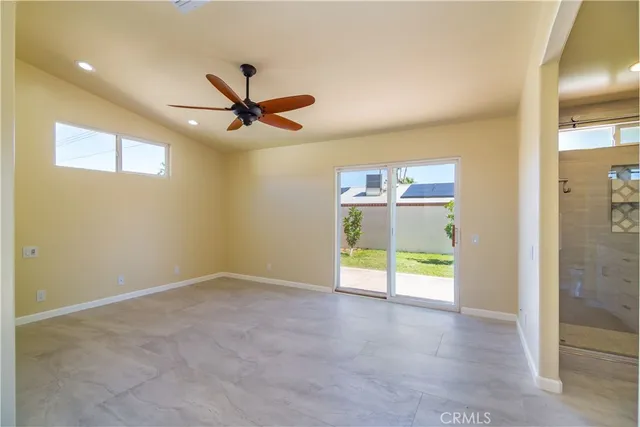 a view of a room with a ceiling fan and window