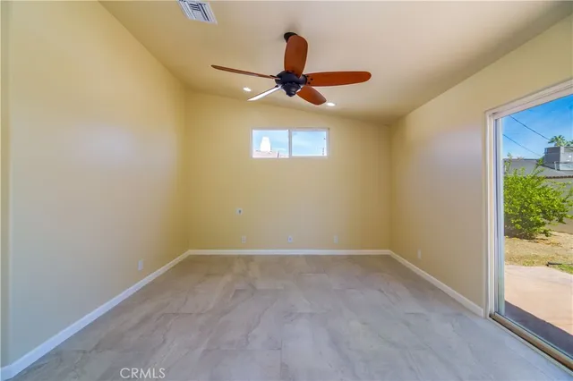 an empty room with fan and windows