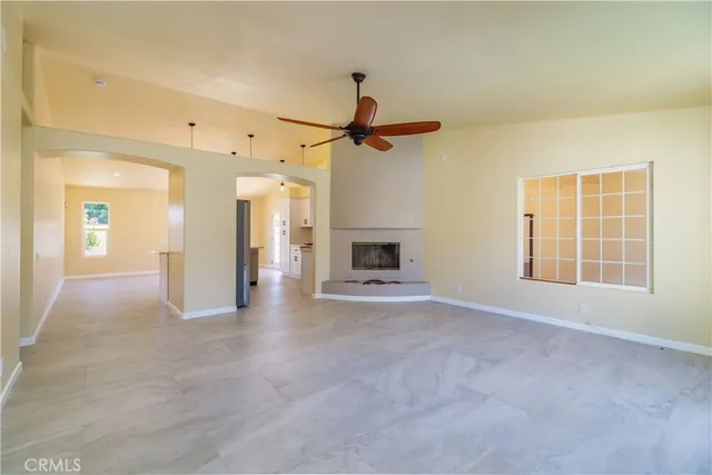 an empty room with a fireplace and fan