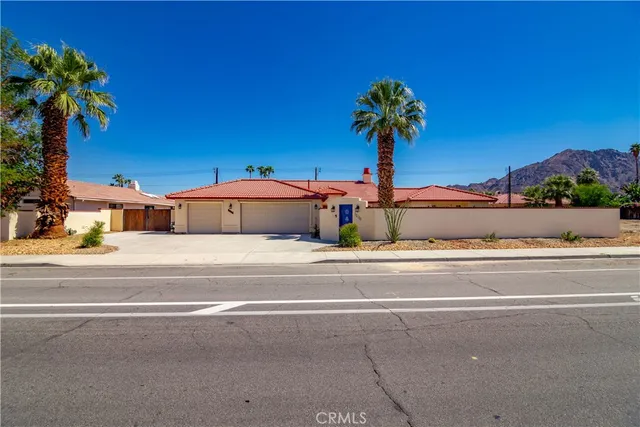 a vase of flowers sitting on a table with potted plants