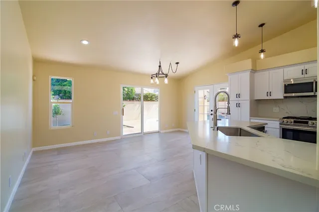 a large kitchen with cabinets a sink a window and stainless steel appliances
