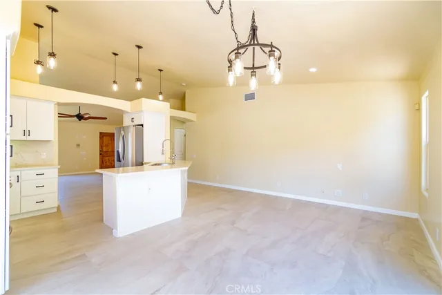 a kitchen with kitchen island a white counter top space cabinets and stainless steel appliances