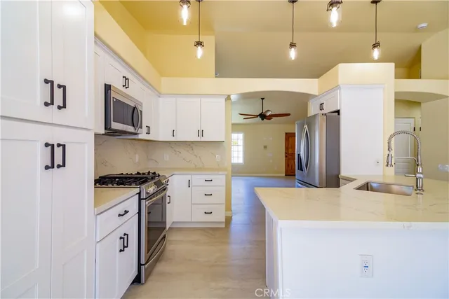 a kitchen with stainless steel appliances granite countertop a sink a stove and a refrigerator