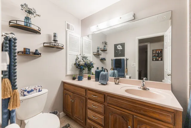 a bathroom with a sink vanity mirror and toilet