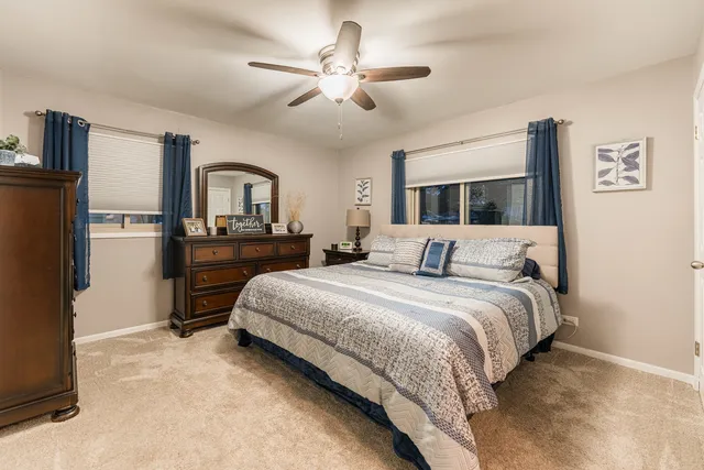 a spacious bedroom with a large bed and a chandelier