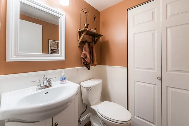 a bathroom with a sink a toilet and mirror