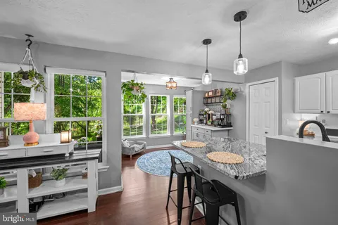 a kitchen with a table chairs stove and wooden floor