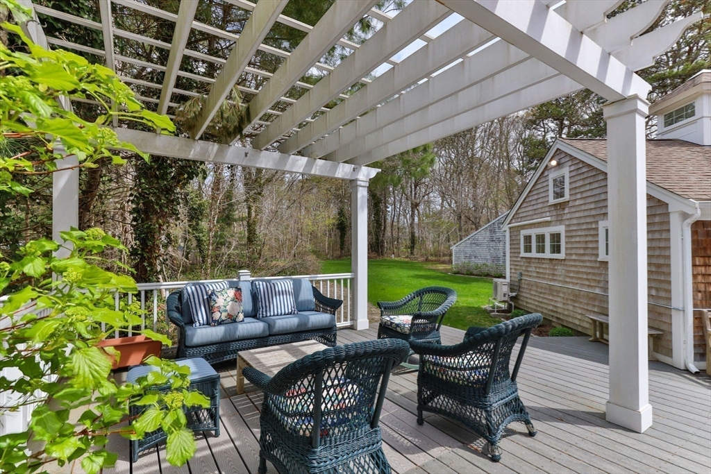 68 Gorham Road Harwich, MA 02646 - Photo 30 of 33 a view of patio with table and chairs potted plants and large tree
