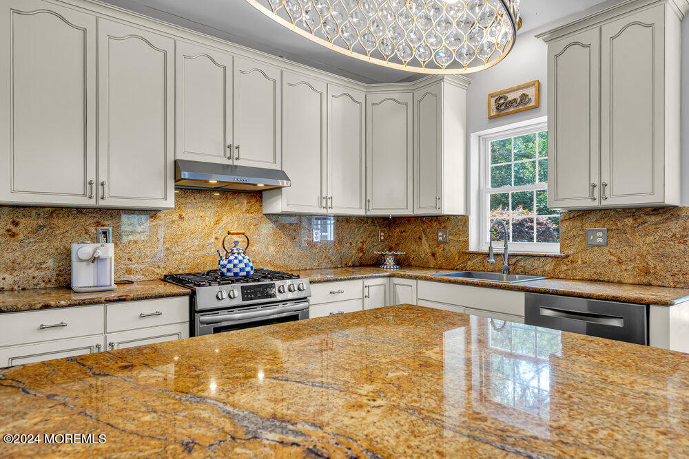 22 Cedar Knoll Road Jackson, NJ 08527 - Photo 20 of 76 a kitchen with kitchen island granite countertop a stove a sink a counter space and cabinets