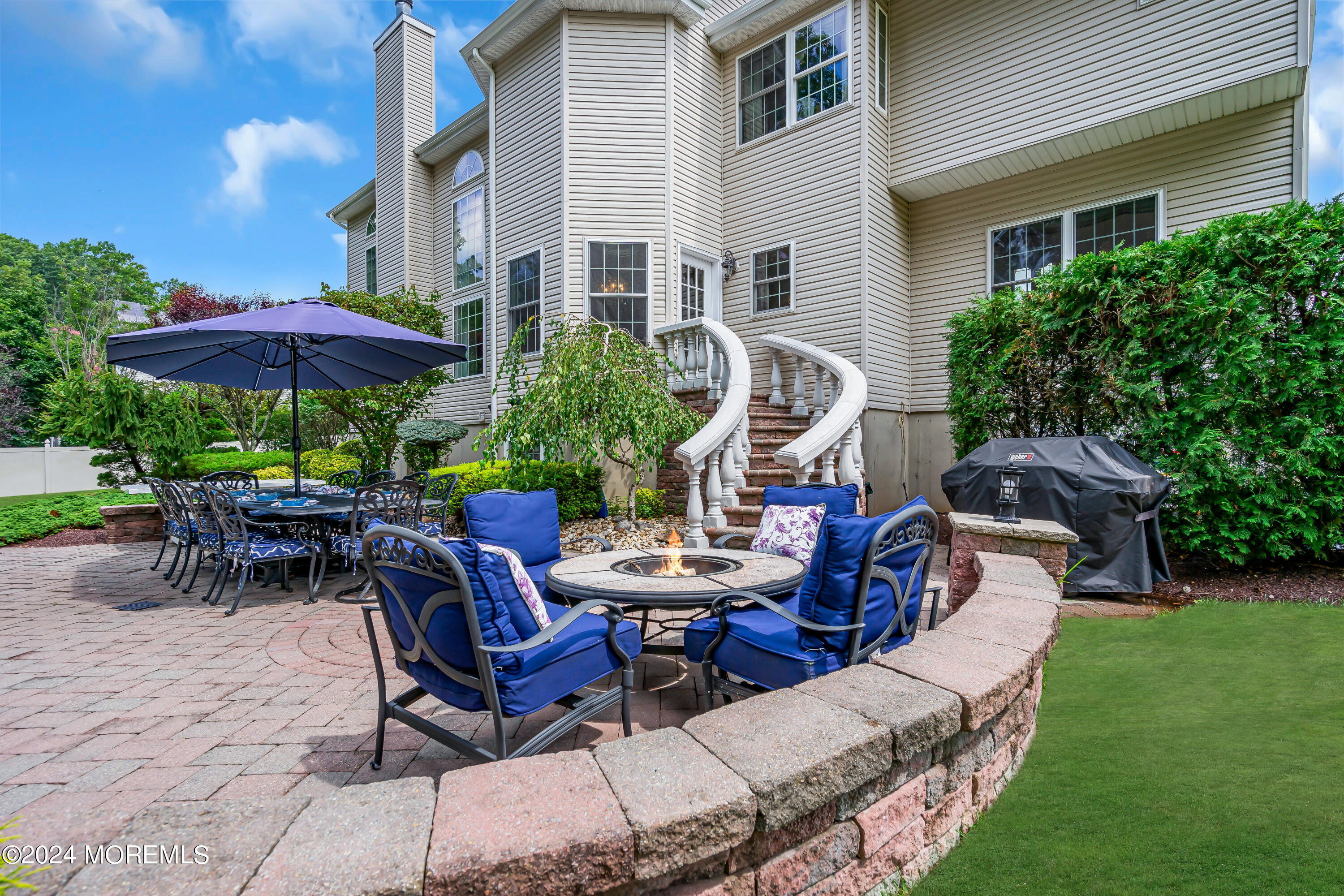 22 Cedar Knoll Road Jackson, NJ 08527 - Photo 71 of 76 a view of a patio with table and chairs under an umbrella with a barbeque grill and plants
