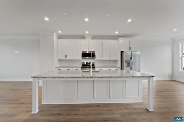 a kitchen with stainless steel appliances granite countertop a sink a stove and a refrigerator