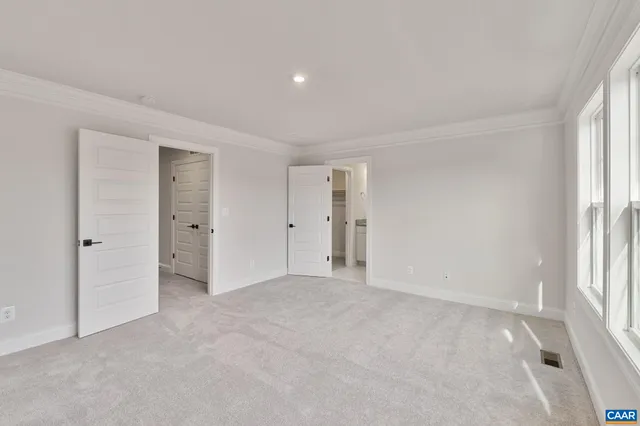 an empty room with a window and a kitchen