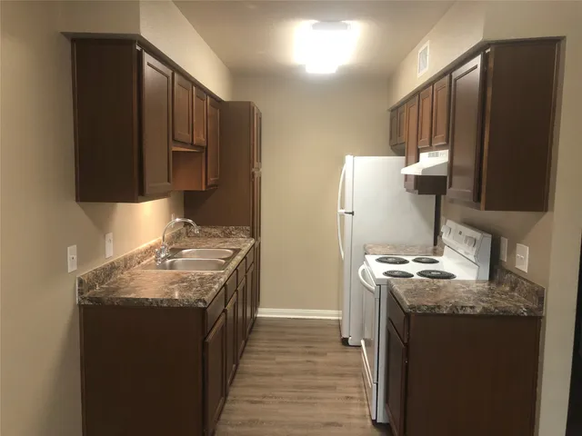 a kitchen with stainless steel appliances granite countertop a stove a sink and a refrigerator