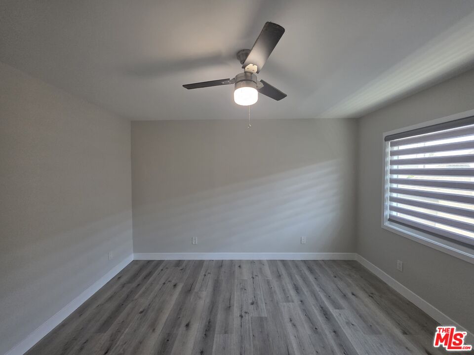 1505 South Cochran Avenue, Unit 4 Los Angeles, CA 90019 - Photo 21 of 45 a view of an empty room with wooden floor and a window
