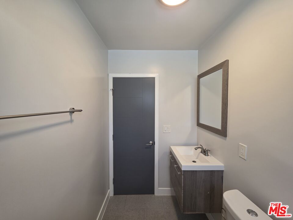 1505 South Cochran Avenue, Unit 4 Los Angeles, CA 90019 - Photo 24 of 45 a bathroom with a toilet sink and mirror