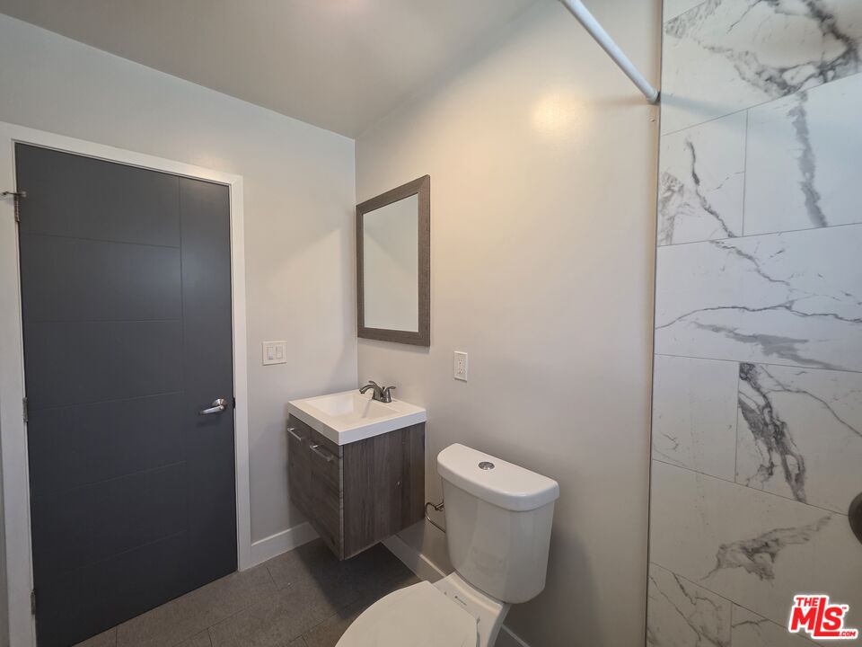 1505 South Cochran Avenue, Unit 4 Los Angeles, CA 90019 - Photo 25 of 45 a bathroom with a toilet sink and mirror