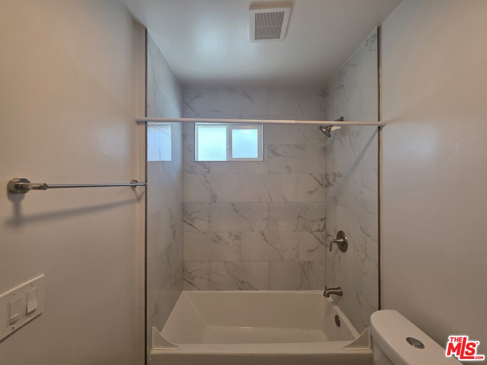 1505 South Cochran Avenue, Unit 4 Los Angeles, CA 90019 - Photo 28 of 45 a bathroom with a bathtub and a toilet