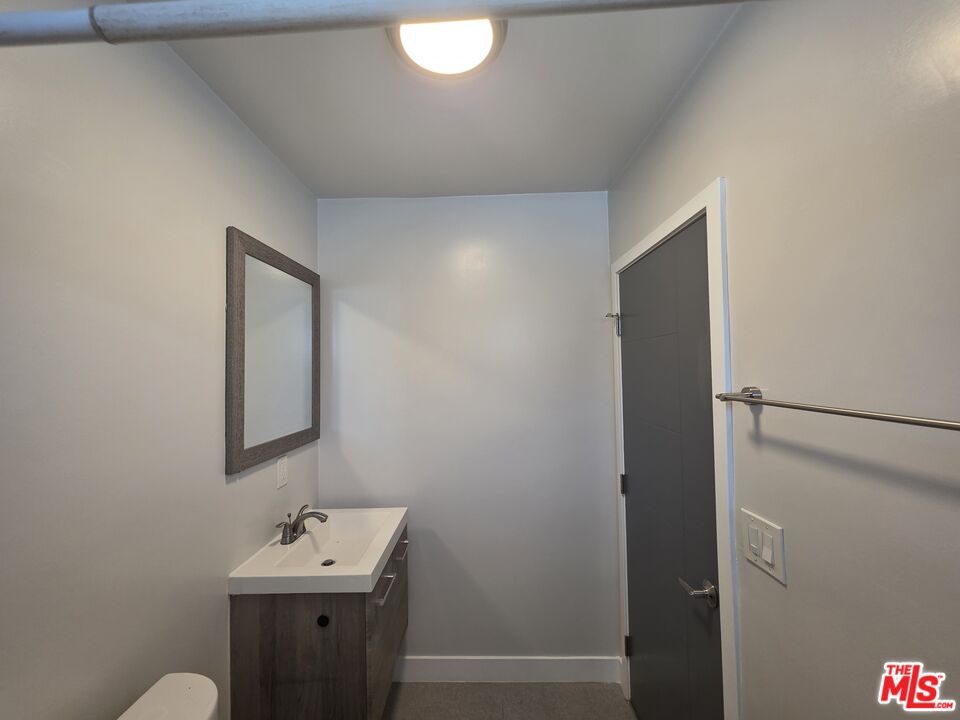 1505 South Cochran Avenue, Unit 4 Los Angeles, CA 90019 - Photo 29 of 45 a bathroom with a sink mirror and vanity